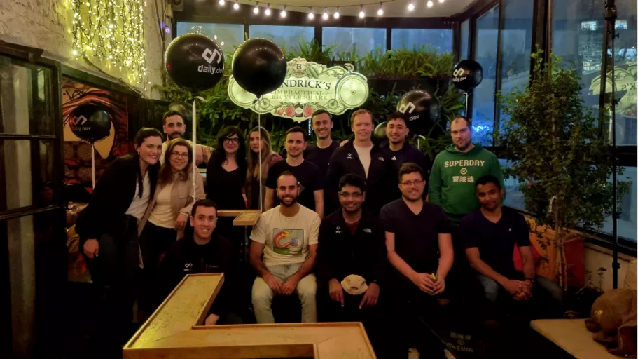 The daily.dev team at a recent offsite, gathered around a long table.